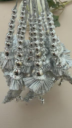 Silver jewelry set with shell-like designs on a beige background