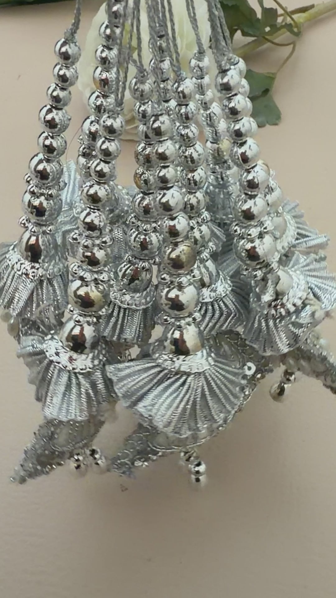 Silver jewelry set with shell-like designs on a beige background