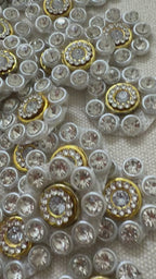 Close-up of decorative buttons with gemstones on a textured fabric background