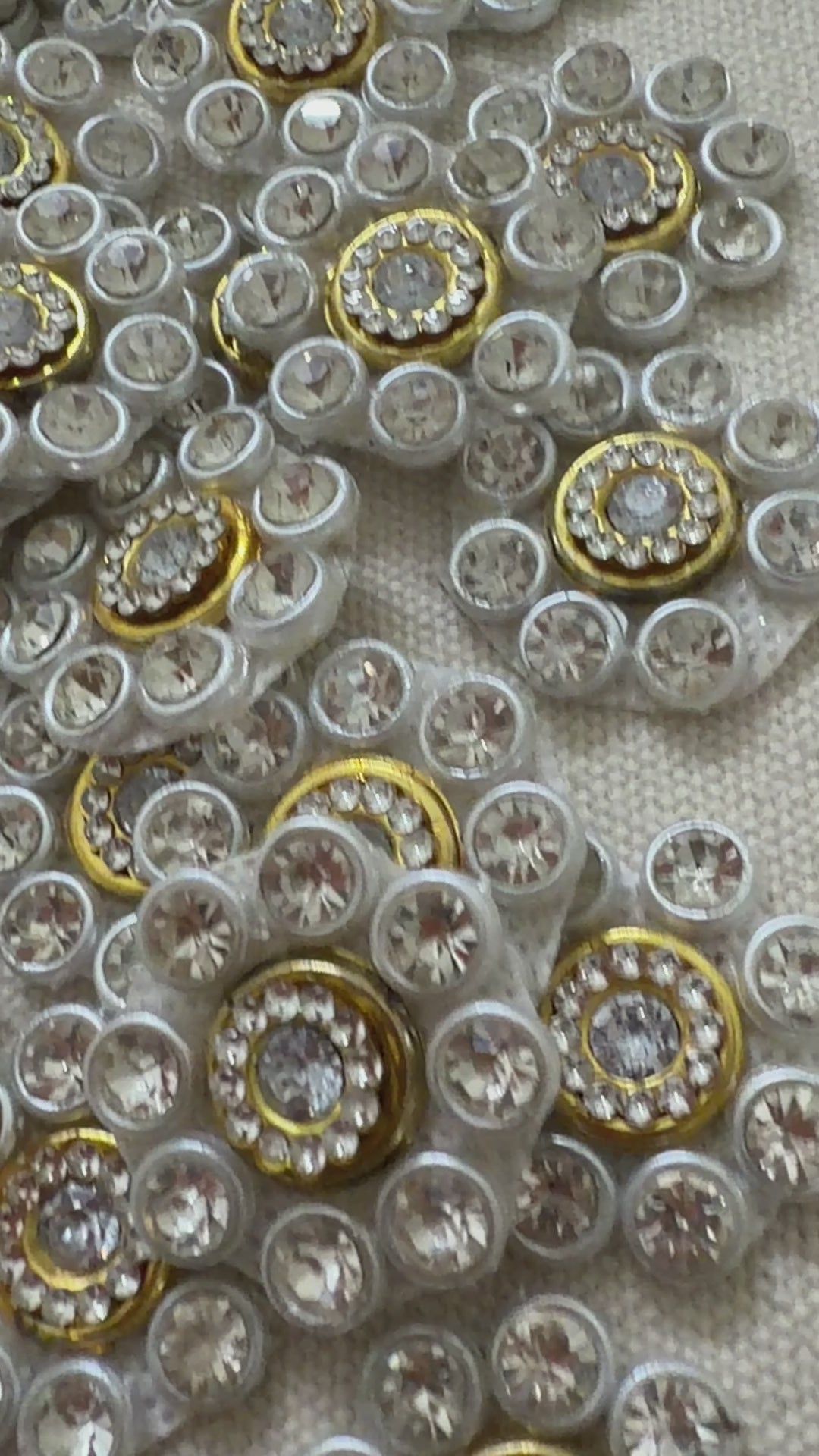 Close-up of decorative buttons with gemstones on a textured fabric background