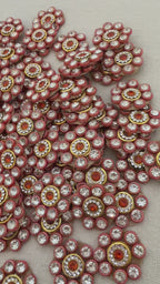 Close-up of decorative buttons with gemstones on a textured surface