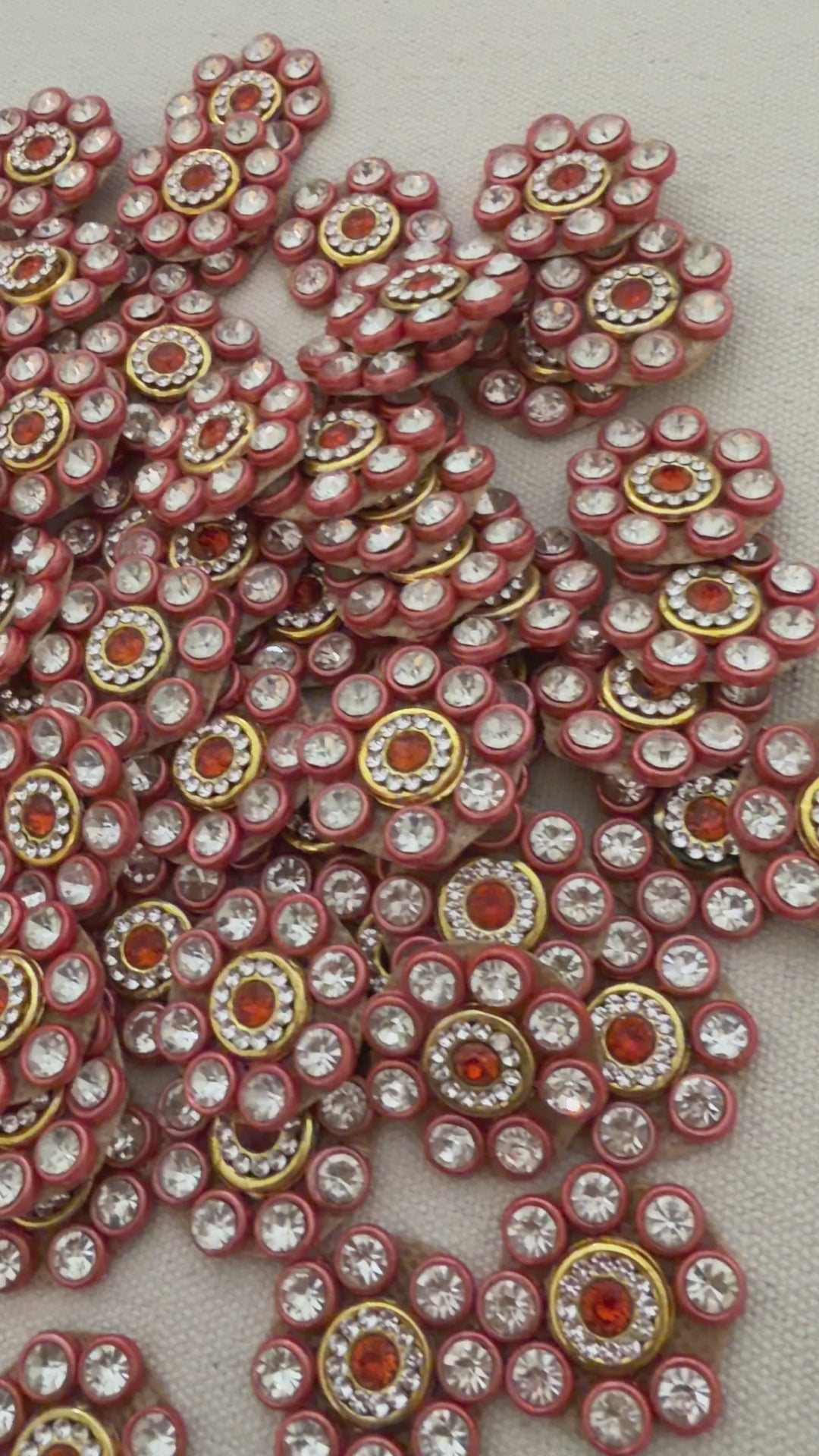 Close-up of decorative buttons with gemstones on a textured surface