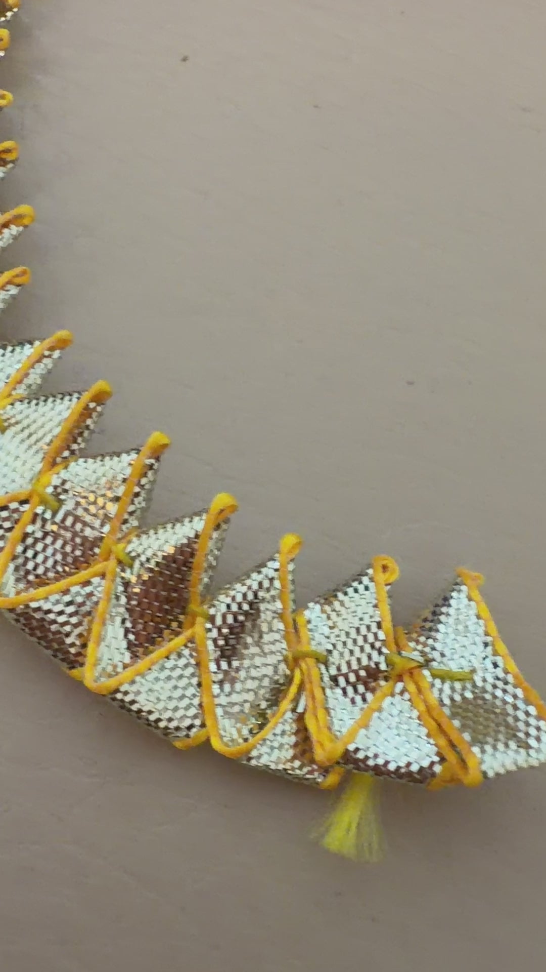 Close-up of gold and silver metallic lace on a beige background