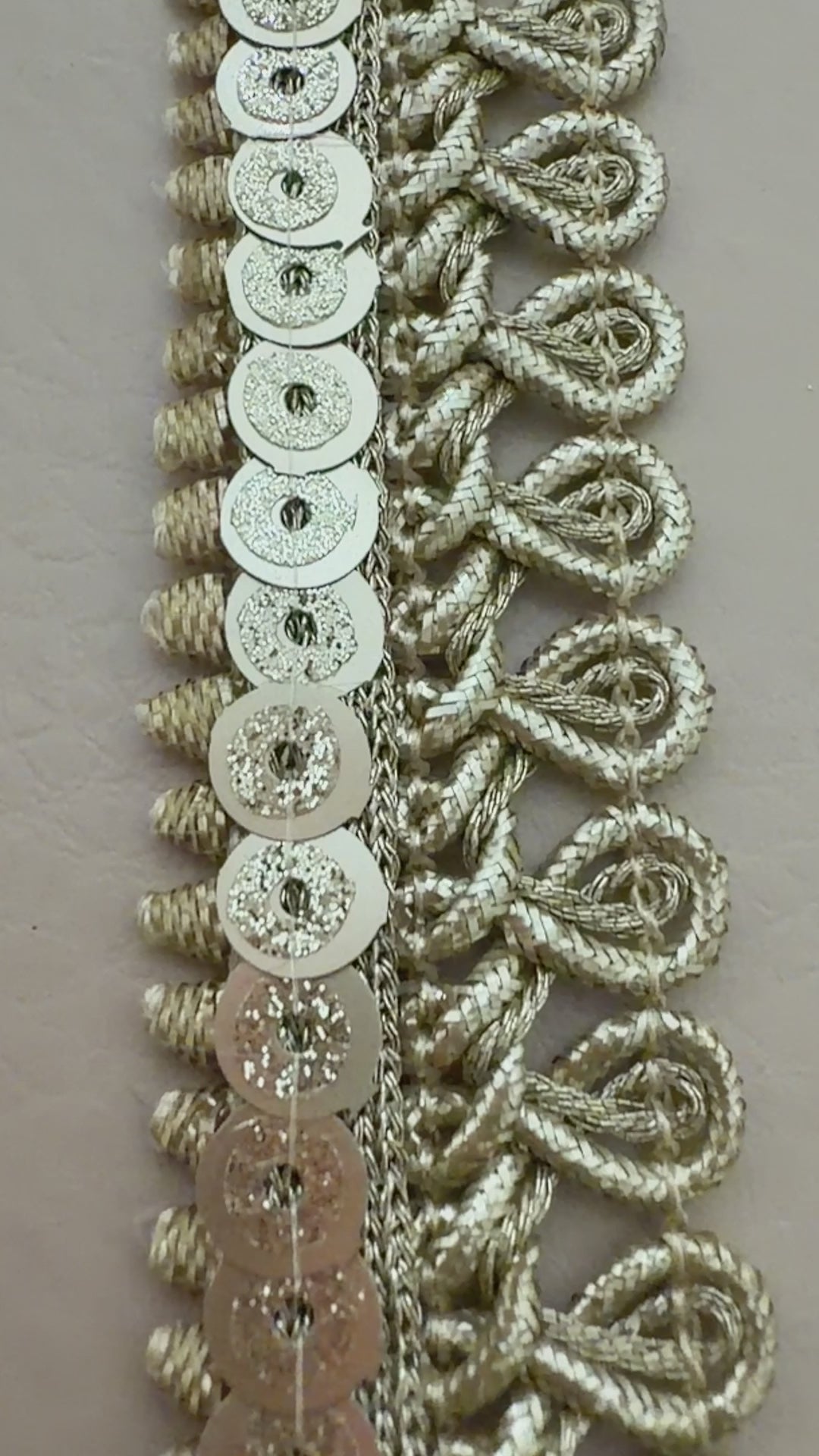 Decorative silver lace trim on a light background with a white flower.