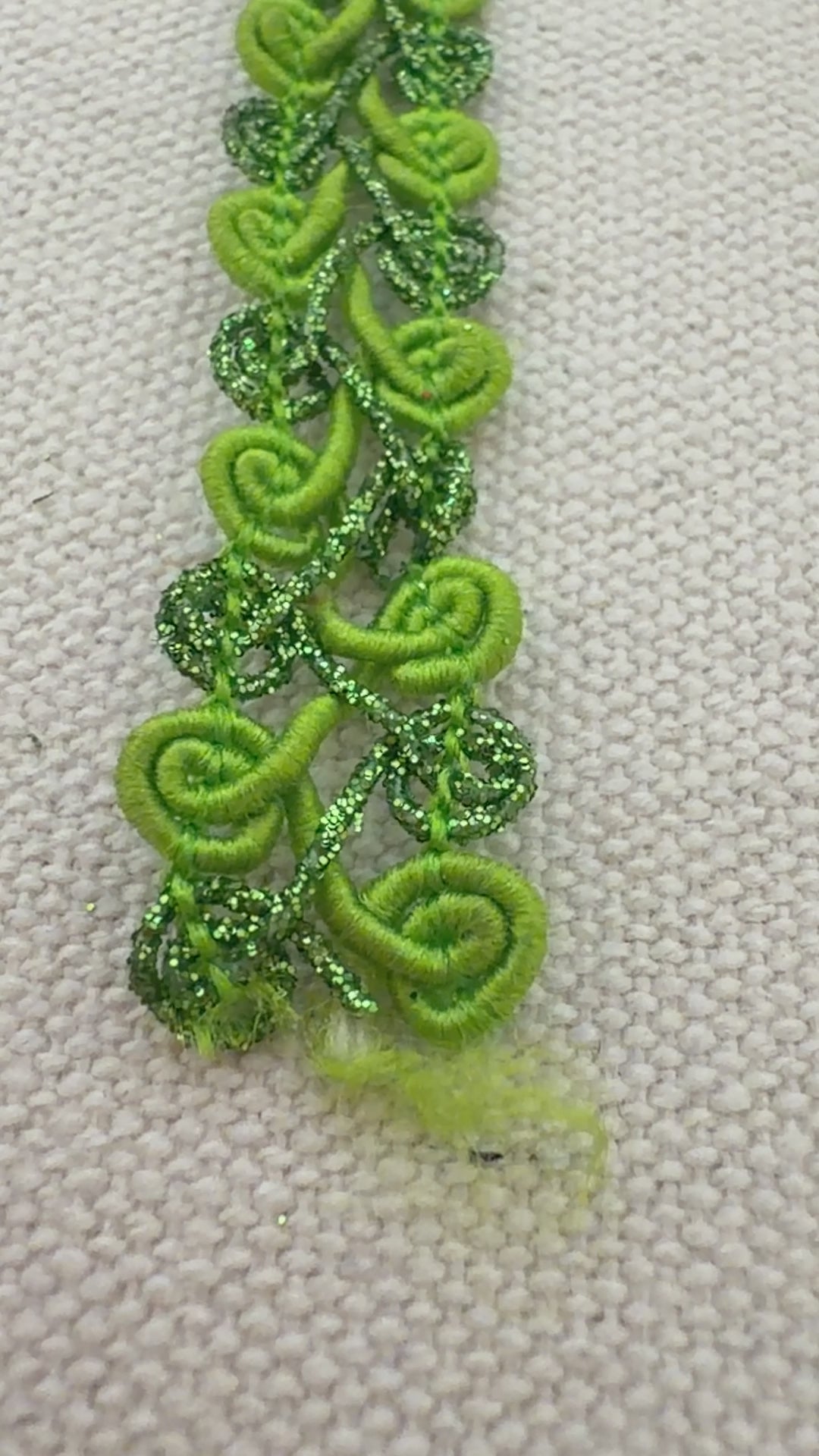 Green textured ribbon roll on a light background