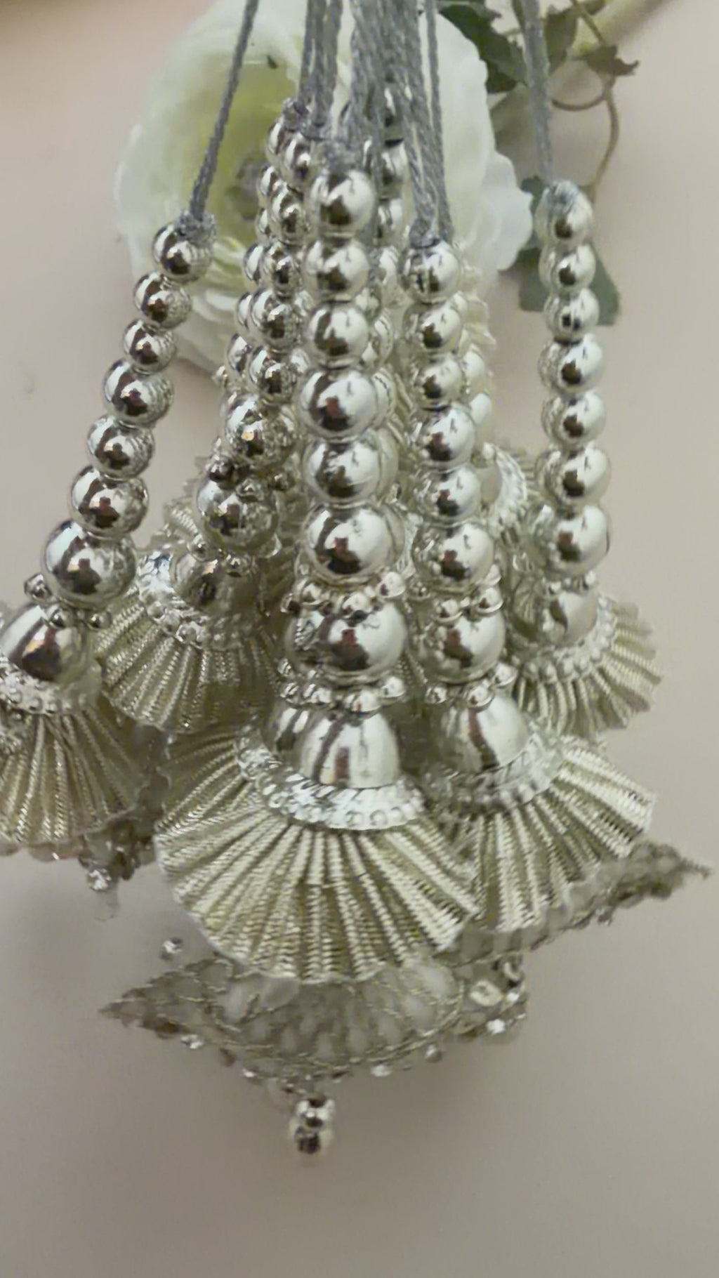 Decorative hairpiece with shell-like elements and beads on a beige background with a white flower.