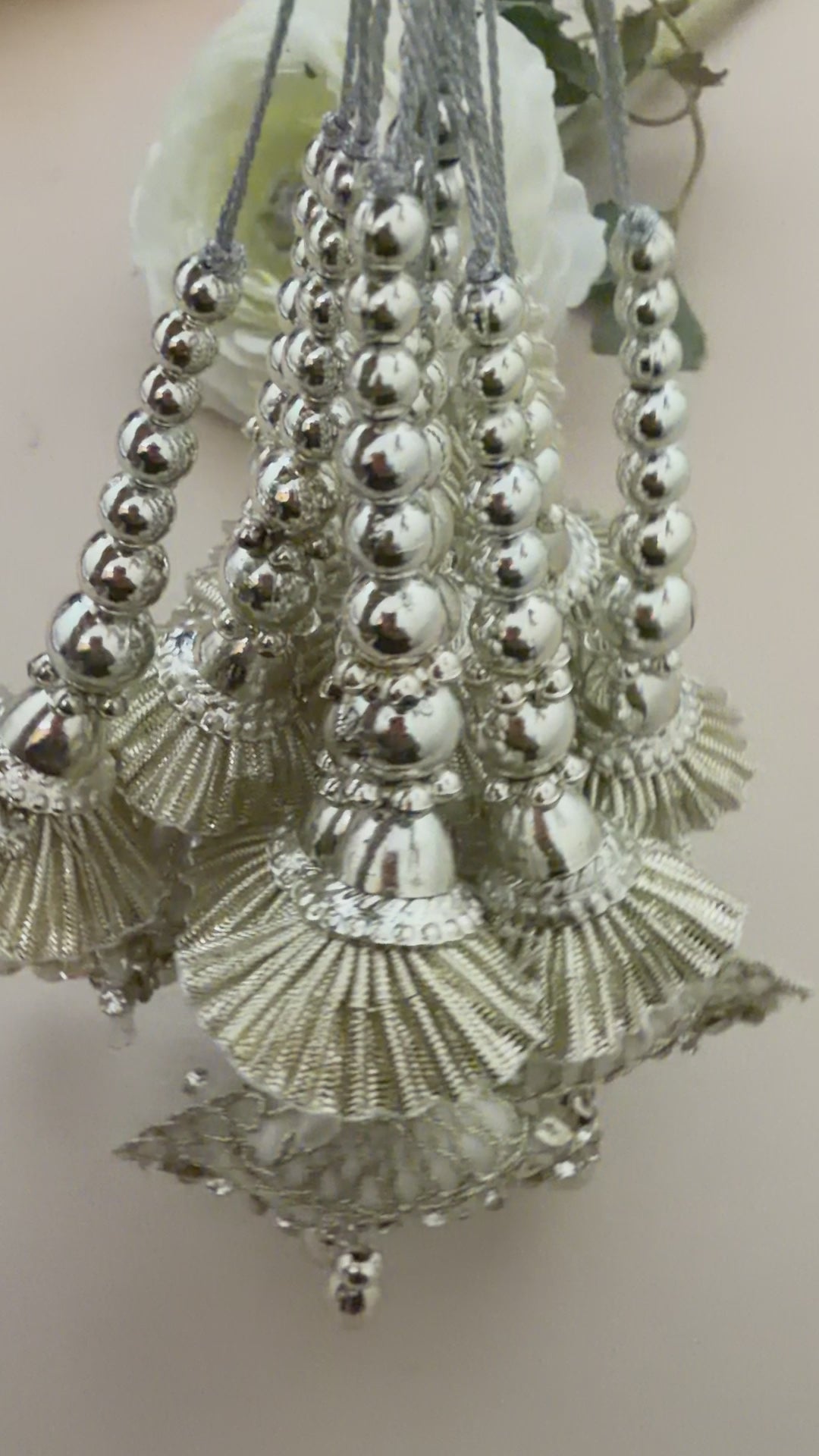 Decorative hairpiece with shell-like elements and beads on a beige background with a white flower.
