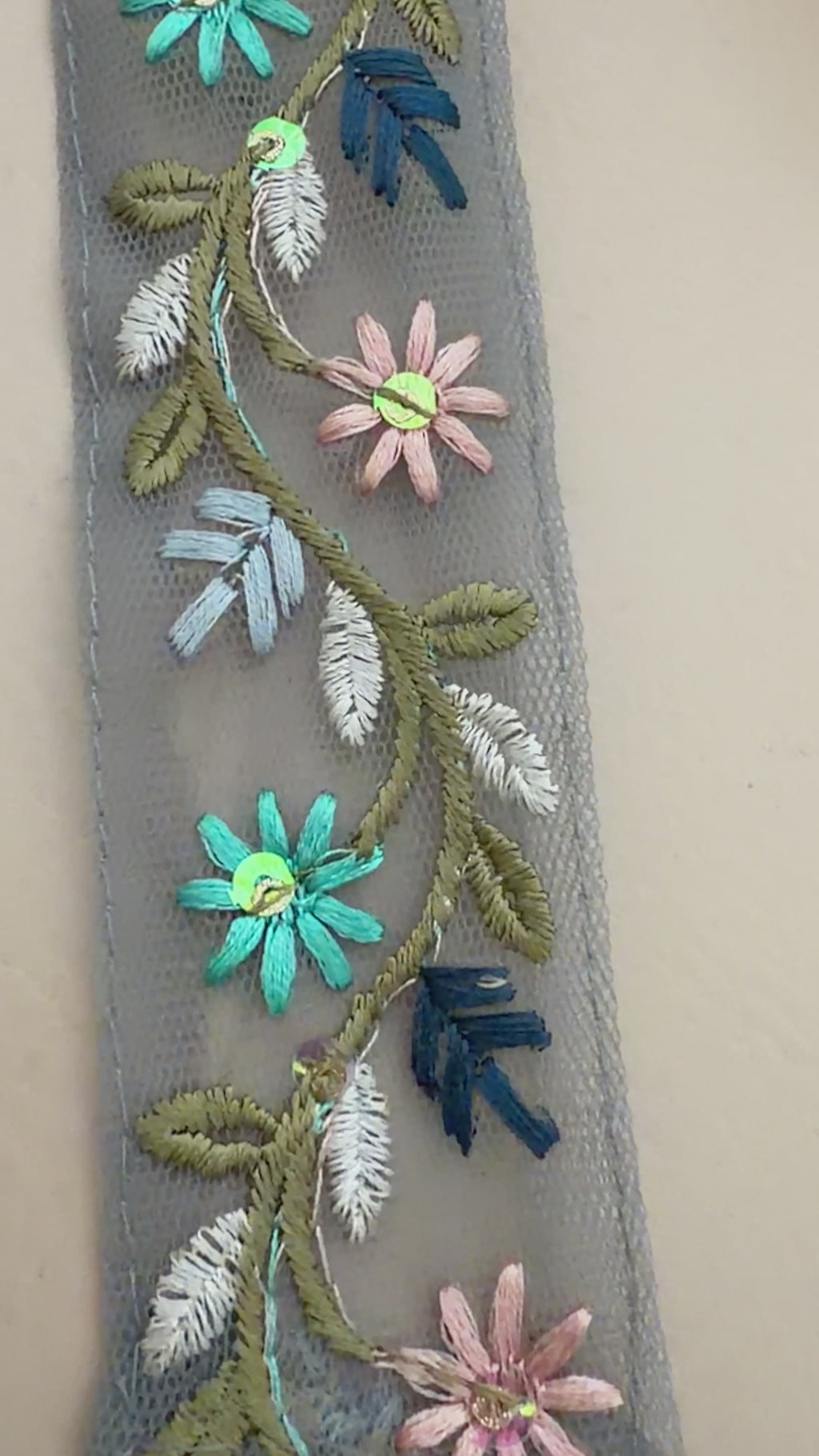 Embroidered beret with floral designs on a beige background
