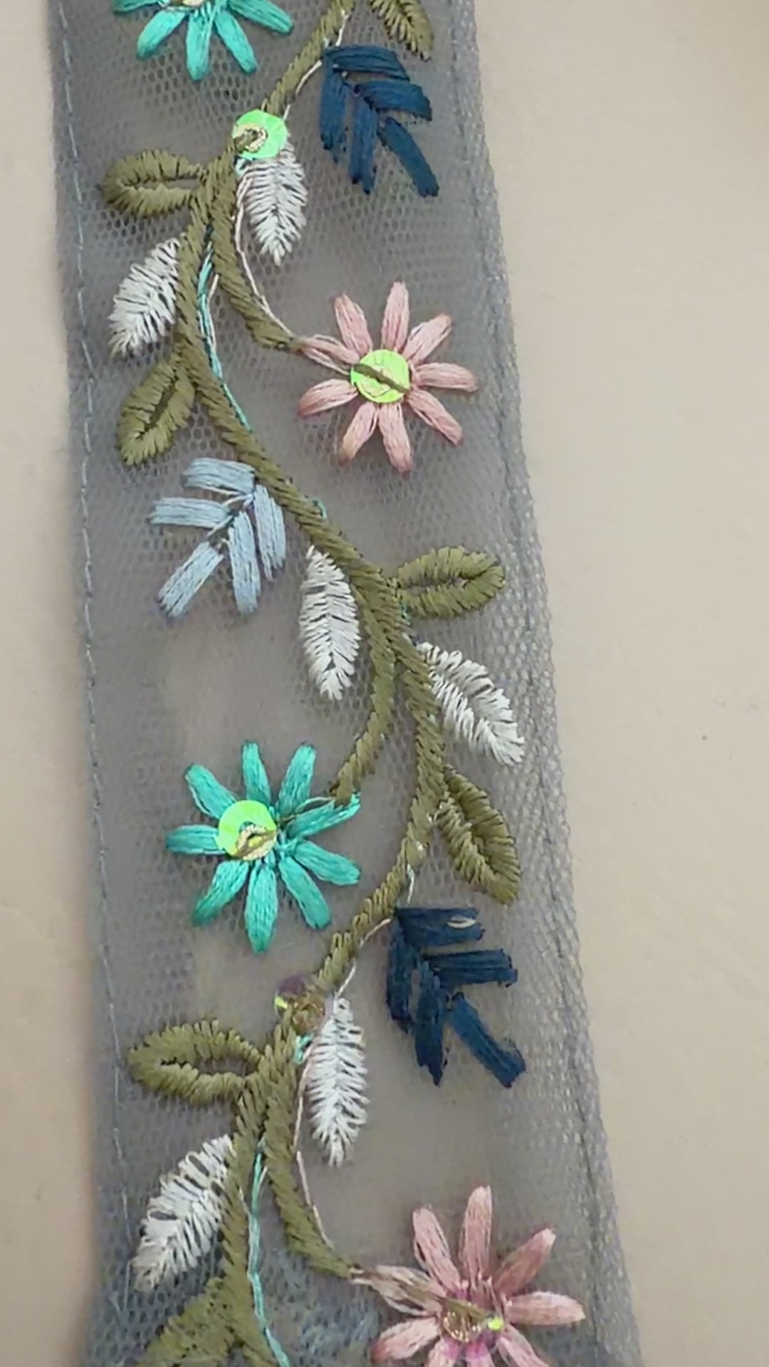Embroidered beret with floral designs on a beige background