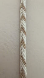Measuring tape showing the thickness of a braided rope on a beige background