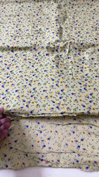 Floral fabric with small flowers in blue, yellow, and purple on a beige background