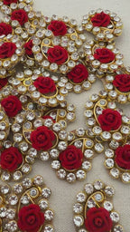 Decorative elements with red roses and gold and silver embellishments on a light background