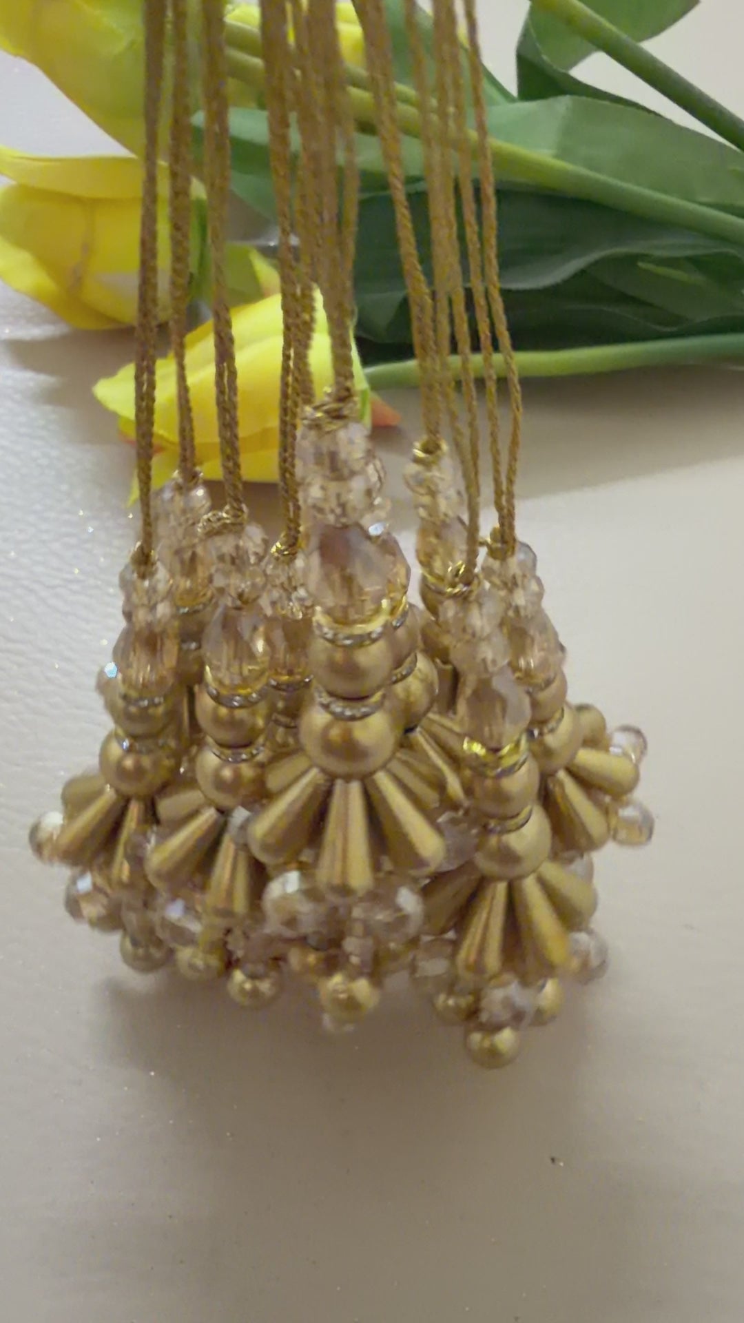 Set of gold beaded tassels on a light background