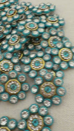 Close-up of decorative buttons with blue and gold colors on a textured surface
