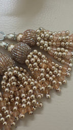 Beaded necklace with tassels on a light background