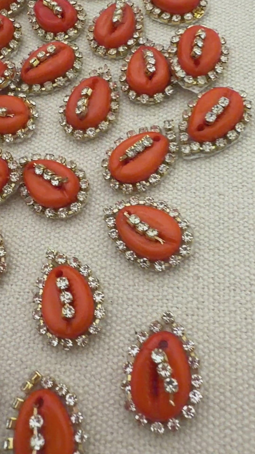 Pattern of red and silver embellishments on a textured white background