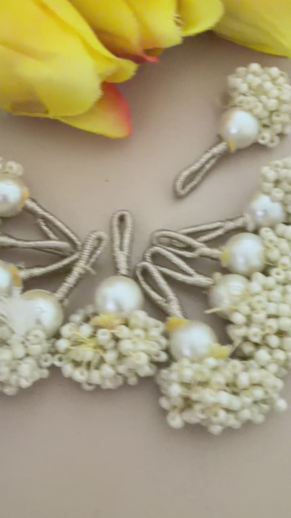 Pearl-like decorative elements with a ruler for scale on a neutral background