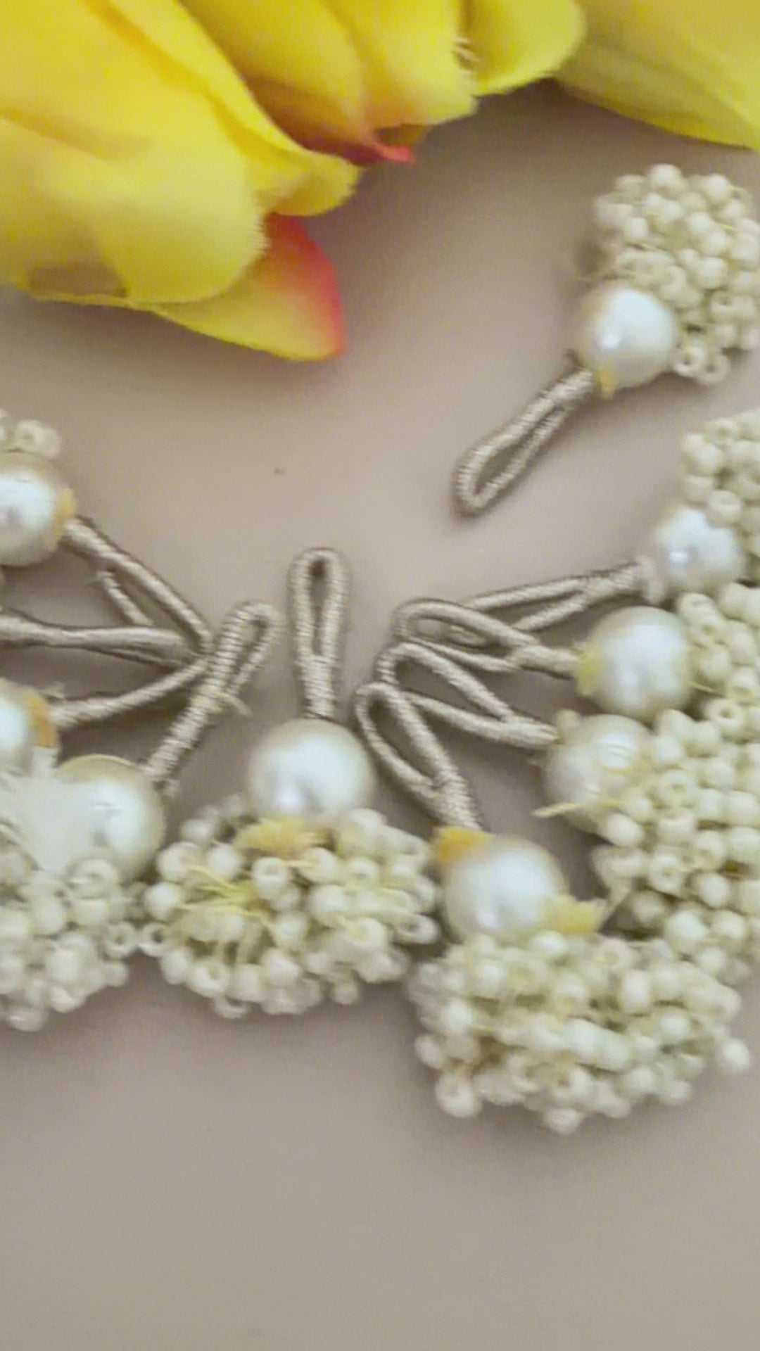 Pearl-like decorative elements with a ruler for scale on a neutral background