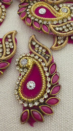 Decorative pink and gold earrings with gemstones on a light background