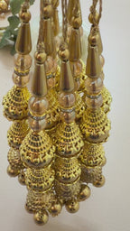 Close-up of a gold necklace with pearl-like beads on a light background