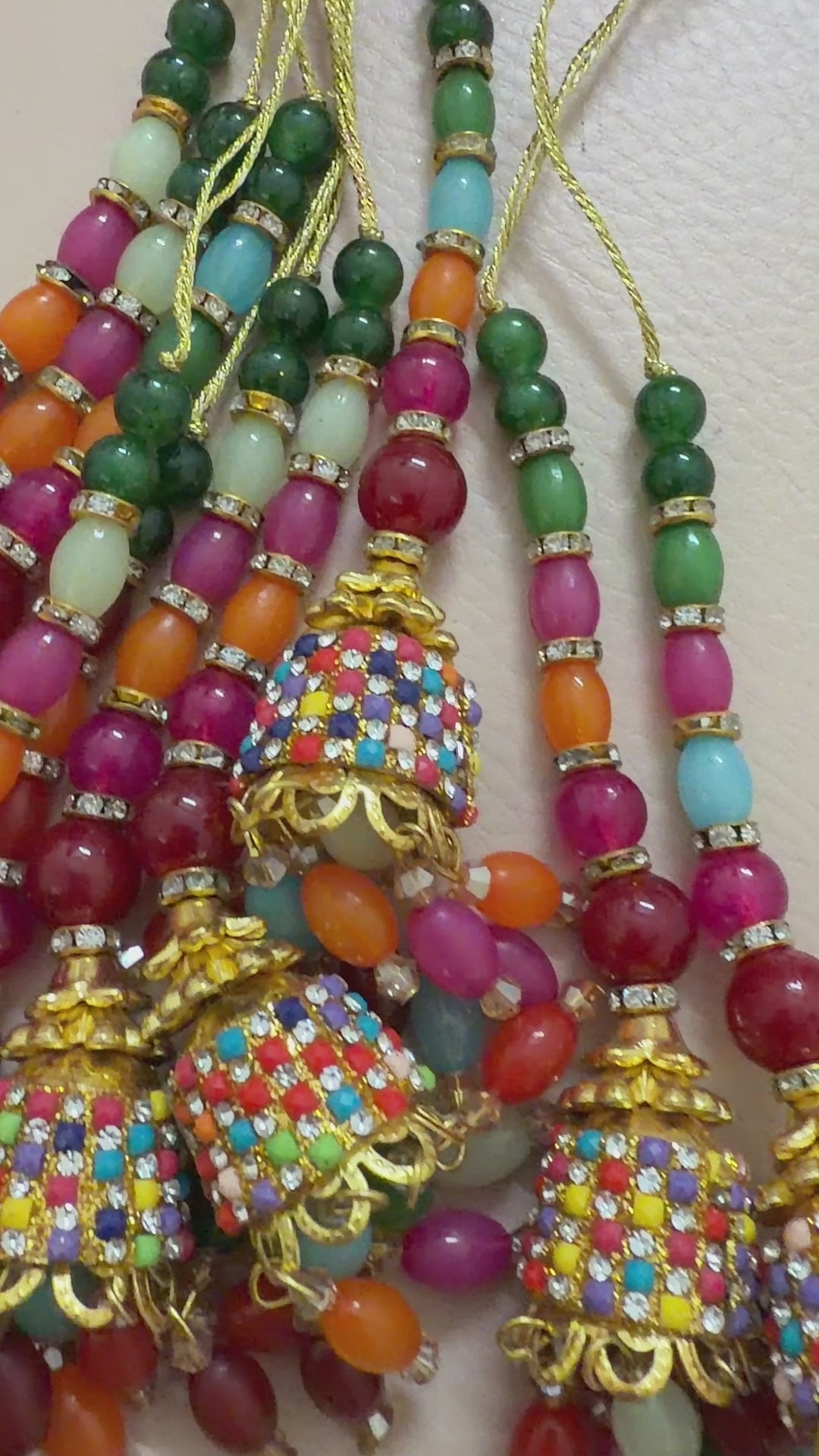 Colorful beaded earrings with gold accents on a light gray background
