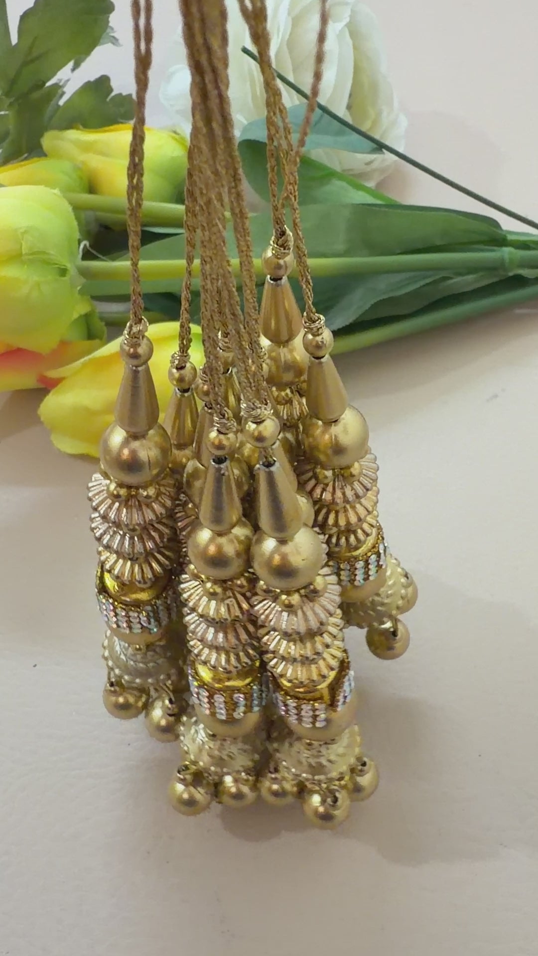 Gold necklace with beads and pendants on a white background