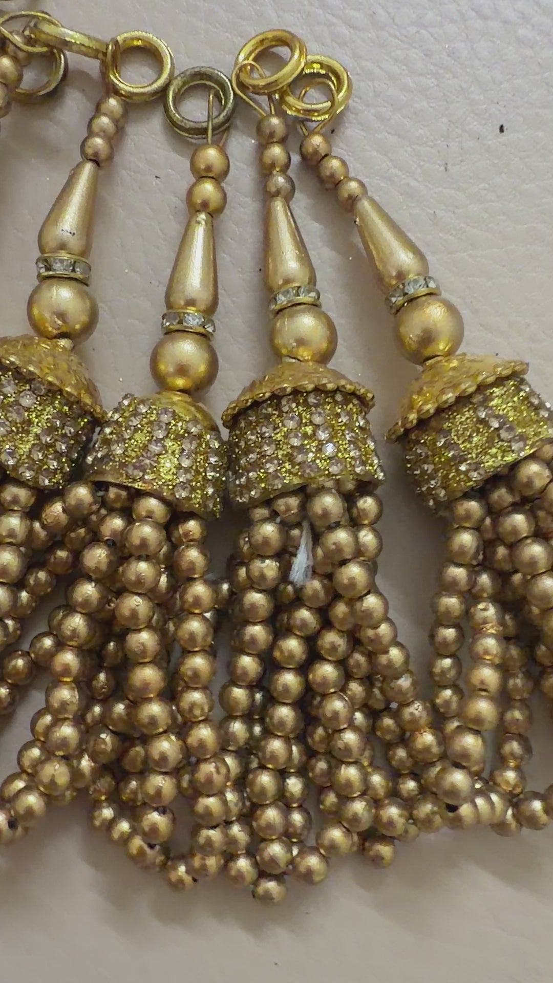 Gold beaded necklace on a light background