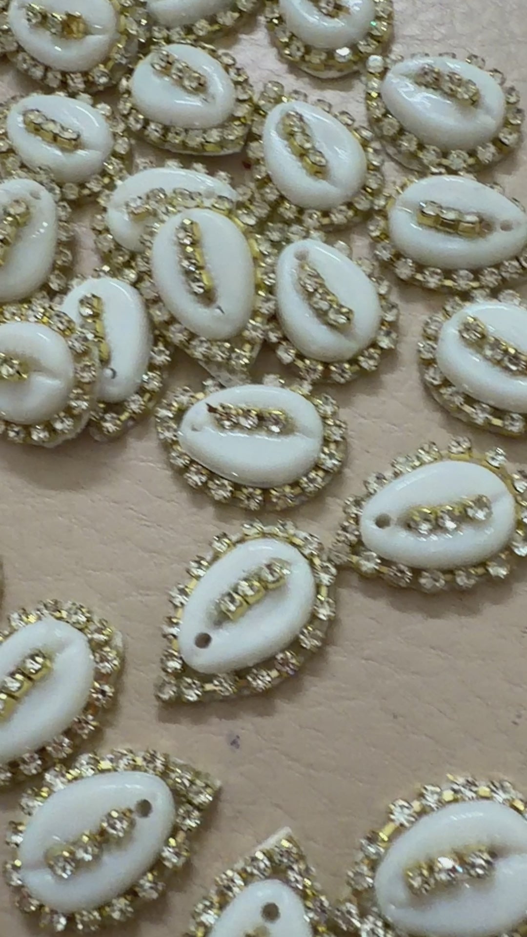 Gold and white decorative item next to a ruler on a beige background