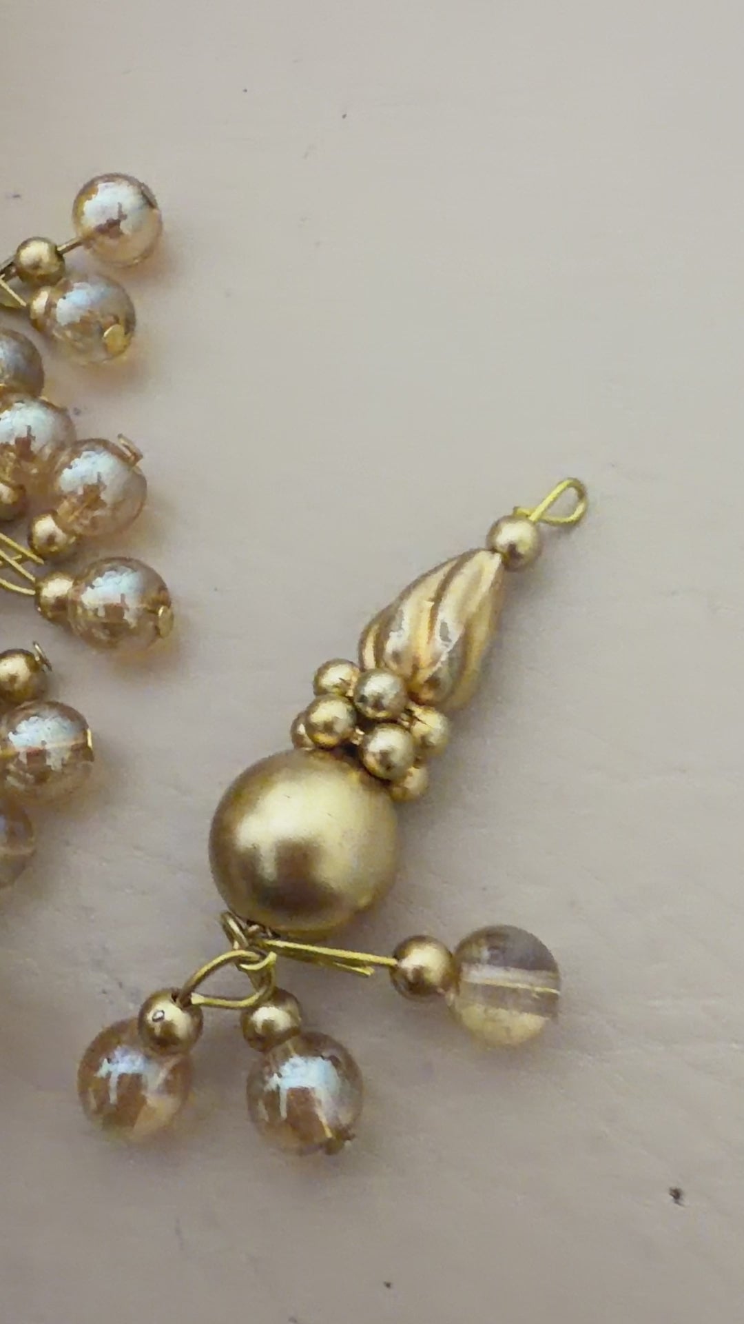 Gold and pearl decorative piece on a light background