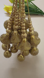 Decorative gold chandelier with hanging beads on a white background