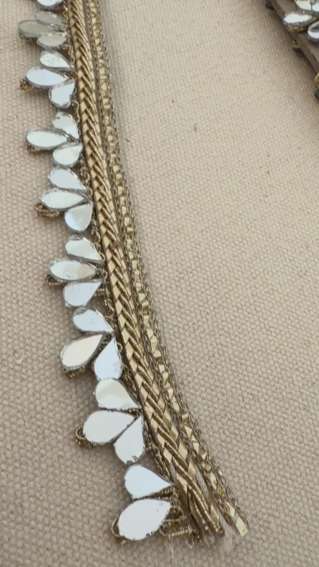 Beaded clutch bag with gold and white accents on a beige background