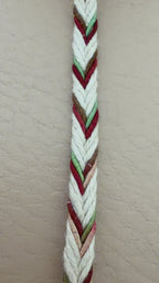 Spool of multicolored braided cable on a beige background