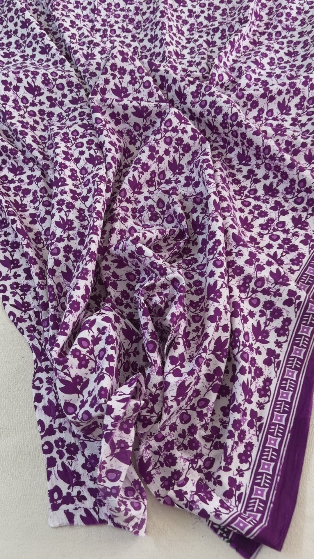 Floral and butterfly patterned fabric with purple flowers and black butterflies on a white background