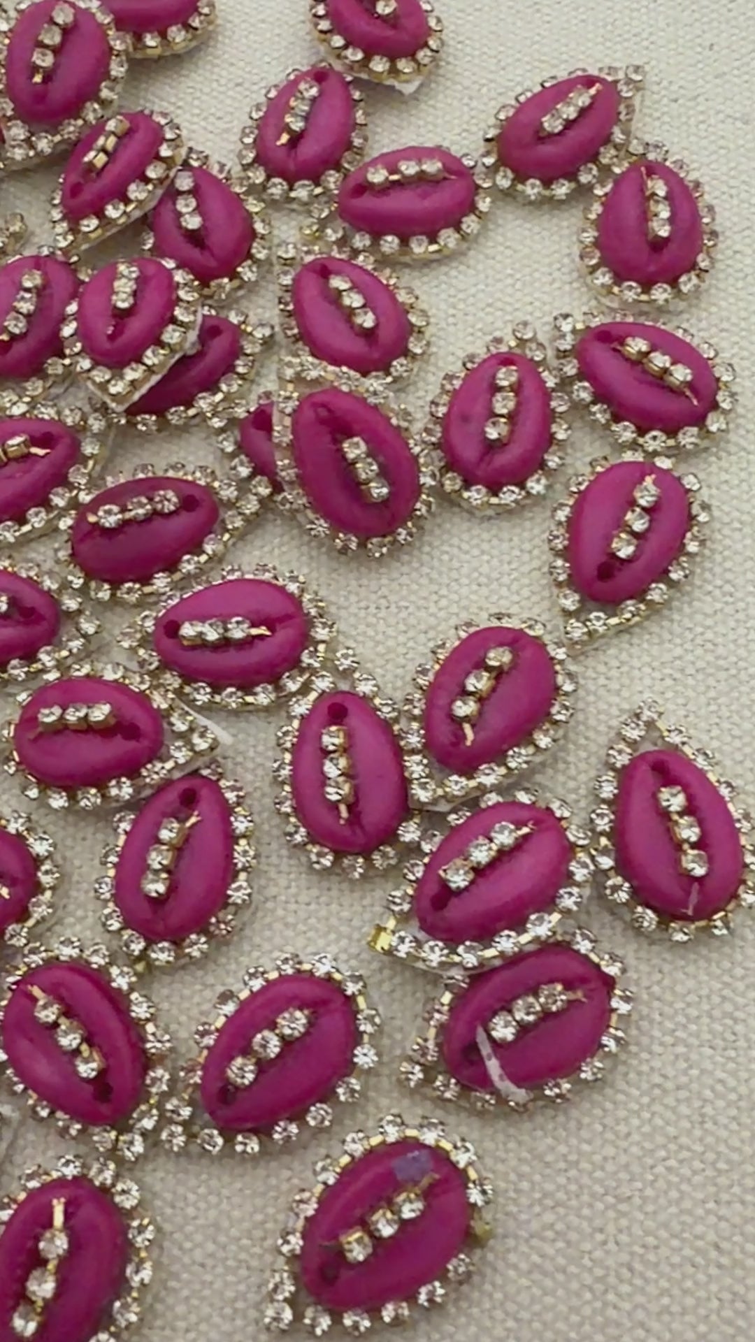 Pink lip-shaped embellishments with rhinestones on a light gray background