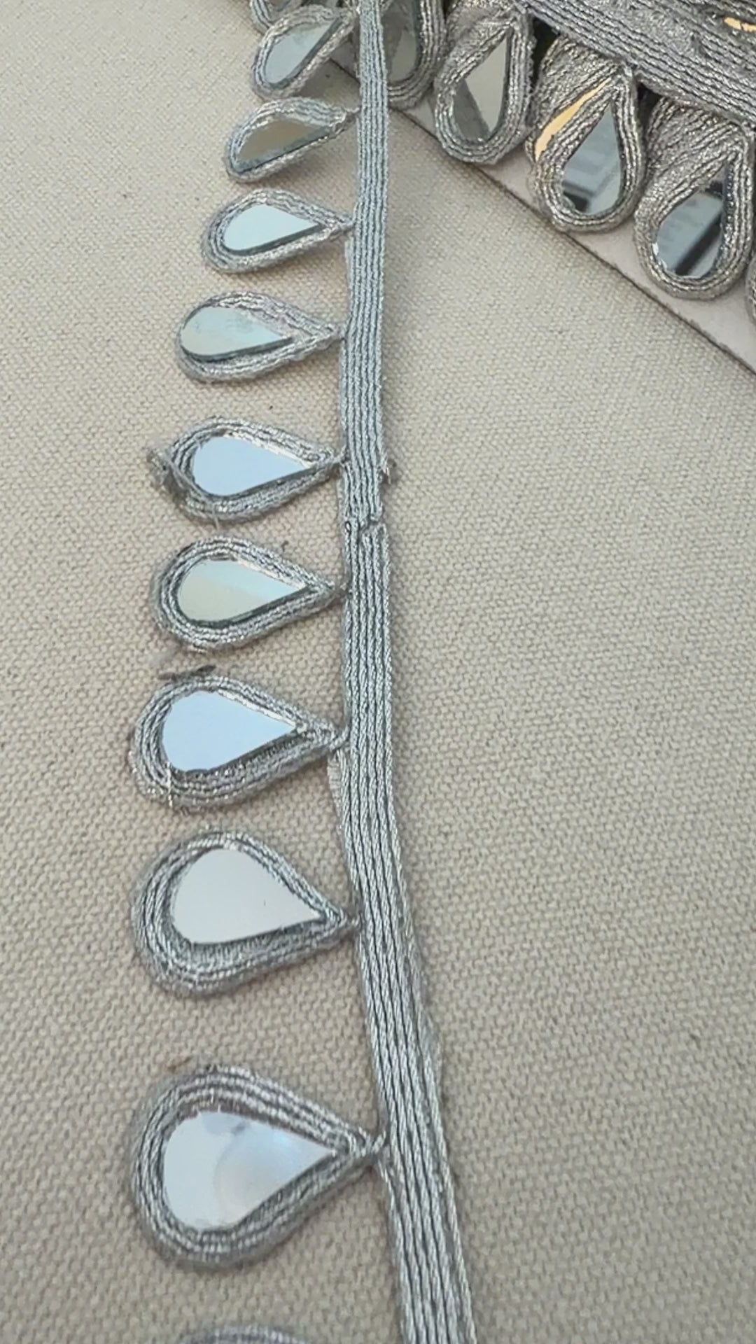 Decorative planter with reflective teardrop designs on a neutral background
