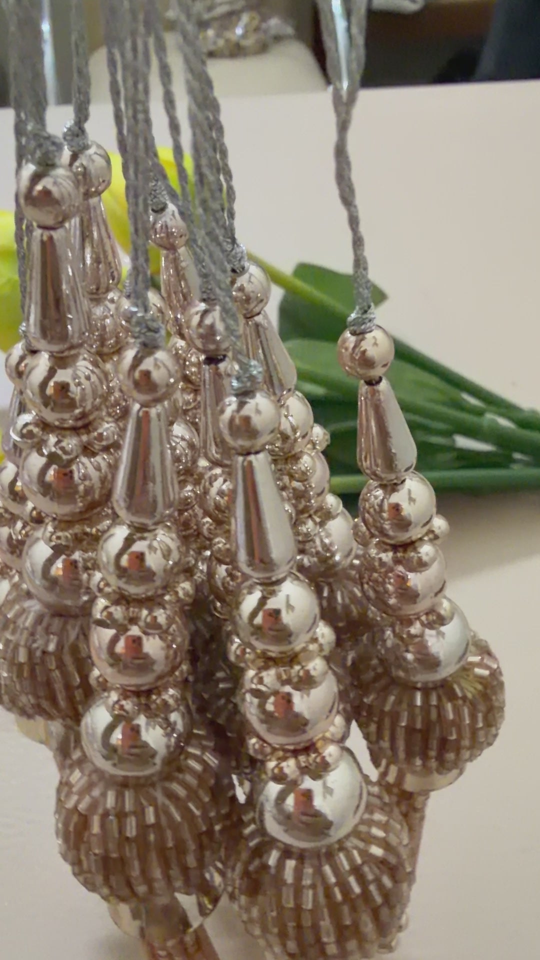 Decorative tassel with a ruler for scale on a light background